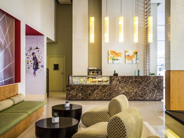 A modern lobby with a marble reception desk, seating area, and artwork on the walls. - ibis Deira Creekside Dubai (Dubai)