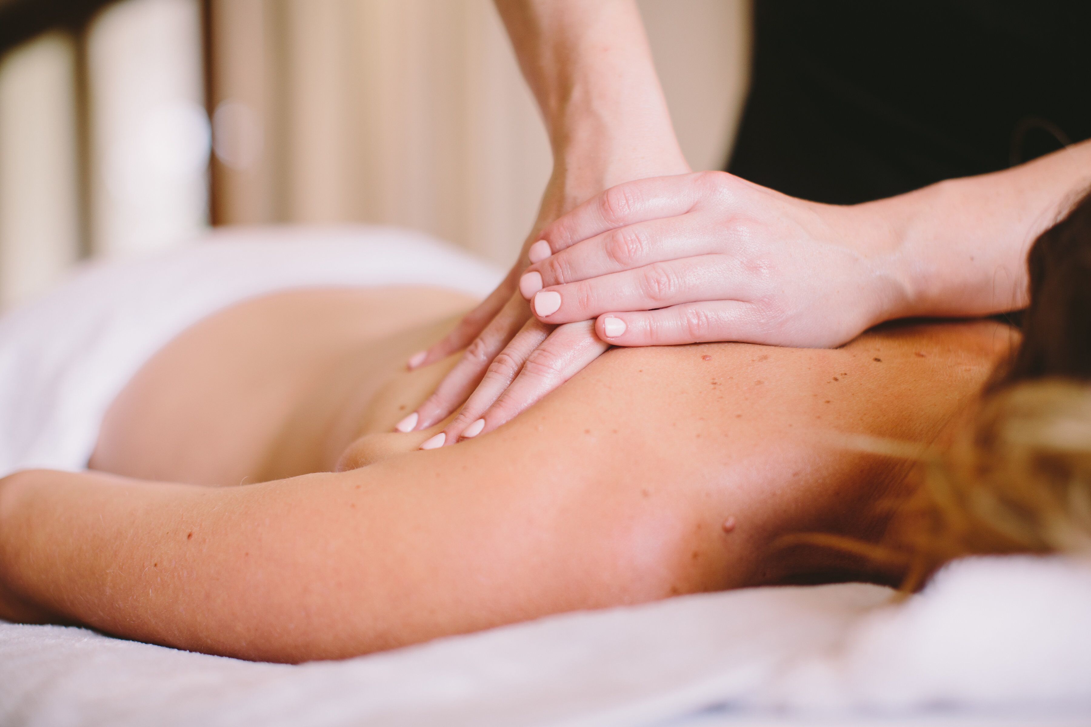 En person modtager en massage af ryggen.