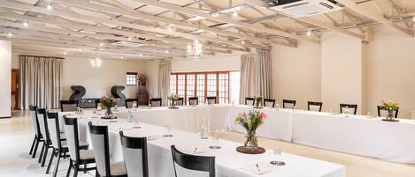 A conference room with a long table, chairs, and a chandelier.