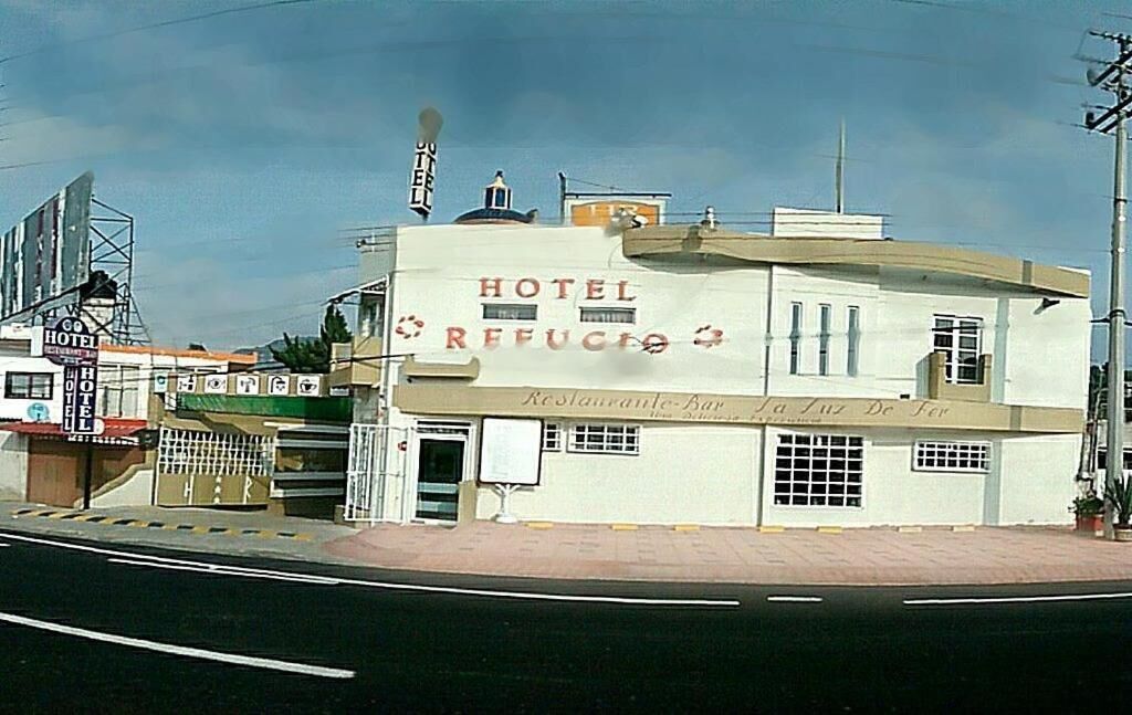 A building with a sign reading 'HOTEL REFUGIO' and 'Restaurante-Bar.'