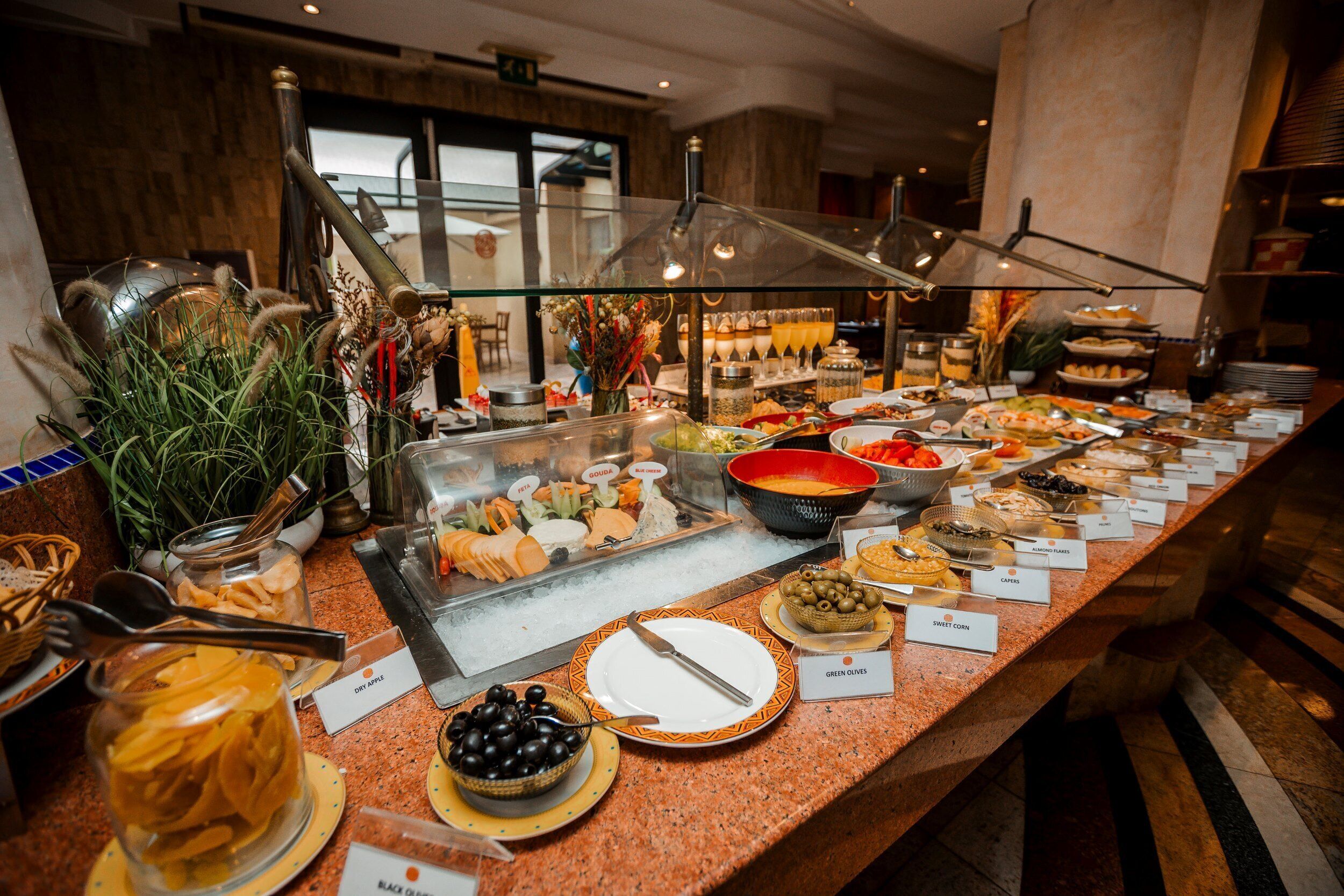 A buffet with various food items and labels.