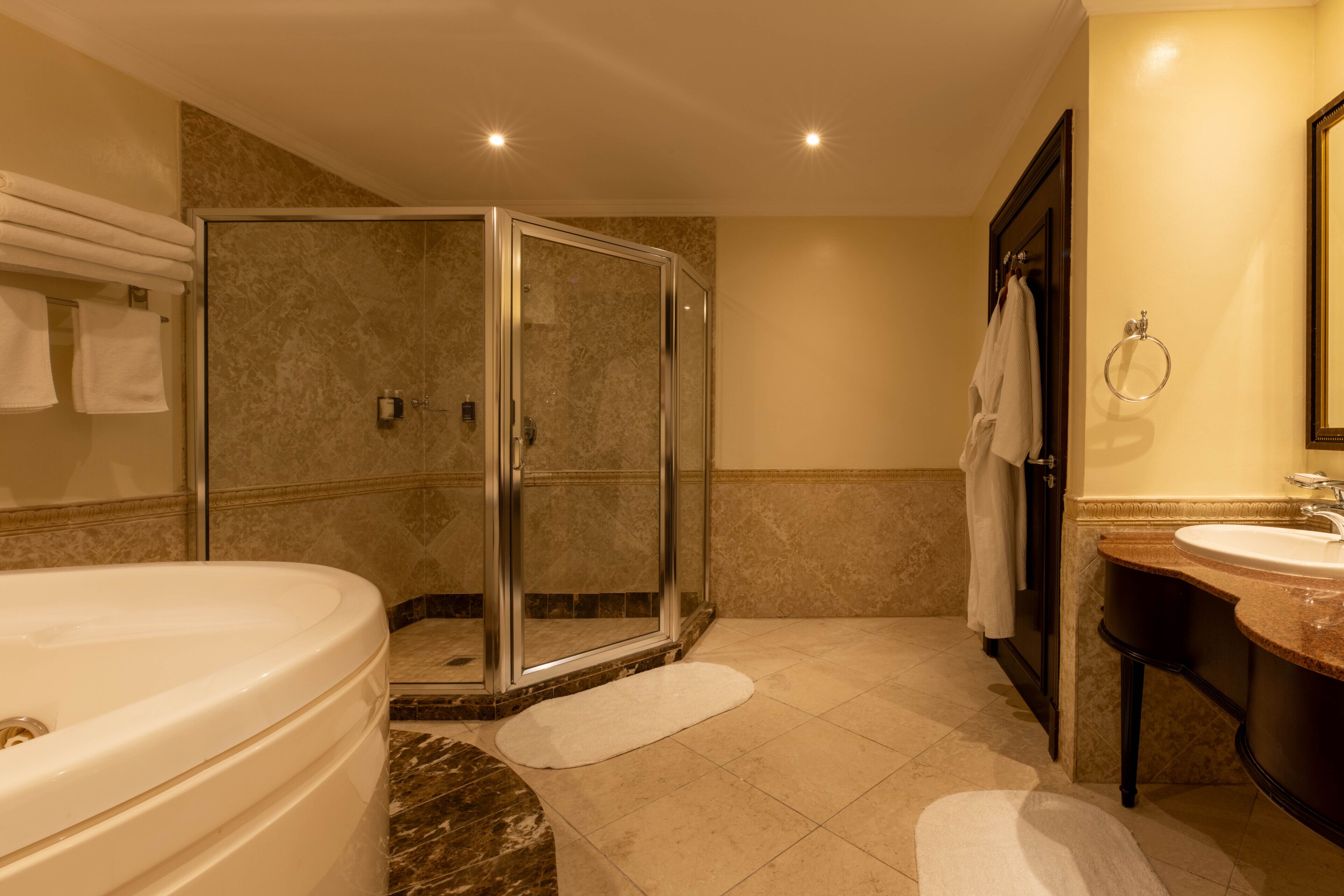 A modern bathroom with a glass-enclosed shower, a large bathtub, and a vanity with a sink.