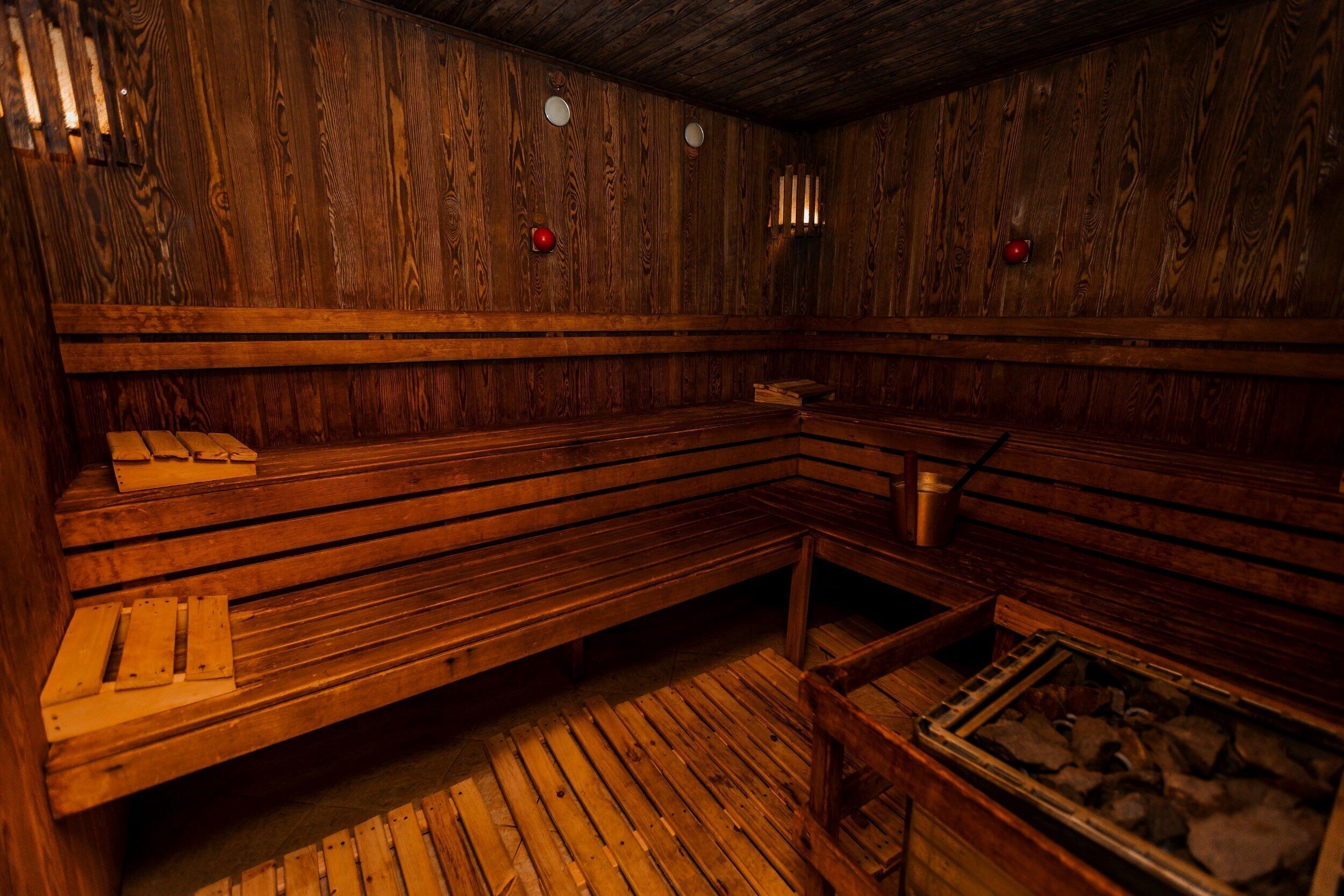 A sauna room with wooden benches and a bench seat, a wooden floor, and a bench seat with a bench seat.