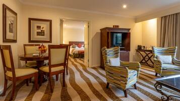 Habitación de hotel con comedor, televisión y cama.