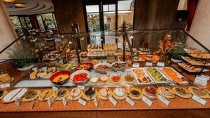 A buffet with various food items and drinks, arranged on a counter with labels. - Kigali Serena Hotel (Kigali)