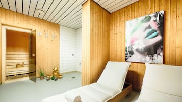 Experience relaxation in this serene spa room, featuring a massage table, Buddha statue, and soothing artwork.