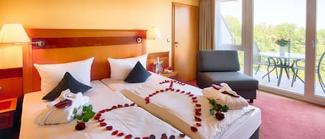 Una habitación de hotel con una cama grande, una silla y un balcón con una mesa y sillas.