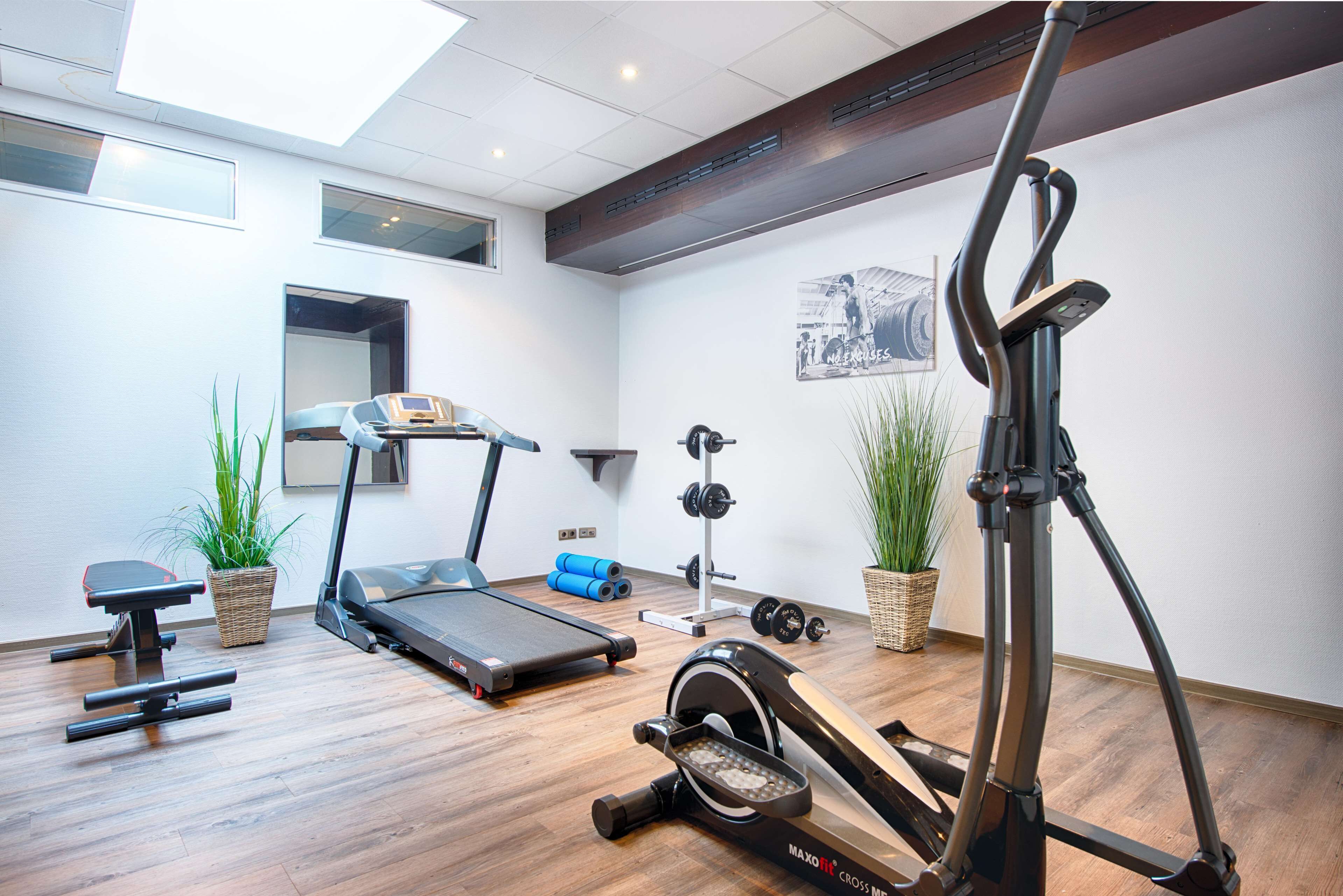 A gym with treadmills, a stationary bike, and free weights.