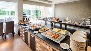 Un buffet proposant une variété de plats et un espace avec des chaises où les convives peuvent s’asseoir.
