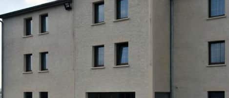 A building with the sign "PRIM HOTEL" on the facade, featuring multiple windows and a flat roof.