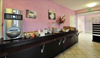 Un área de recepción con una máquina de café, un letrero en la pared que dice "MOCHA" y un mostrador con diversos artículos.