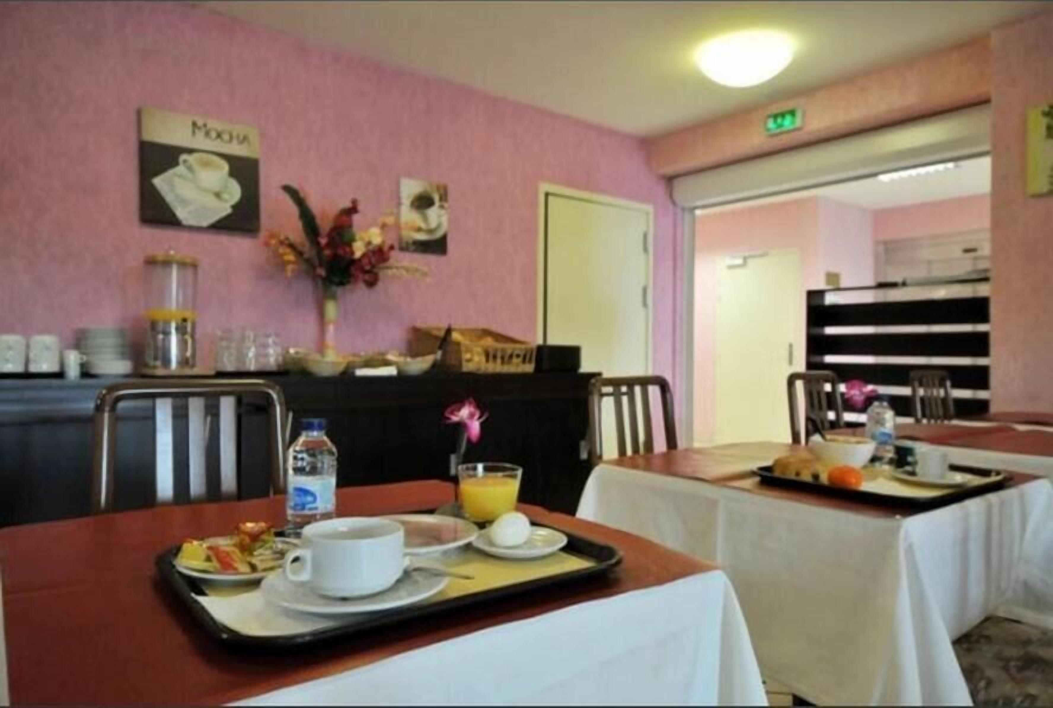 Ein Essbereich mit gedeckten Tischen zum Frühstück, darunter Tabletts mit Speisen, Getränken und einer Kaffeetasse.