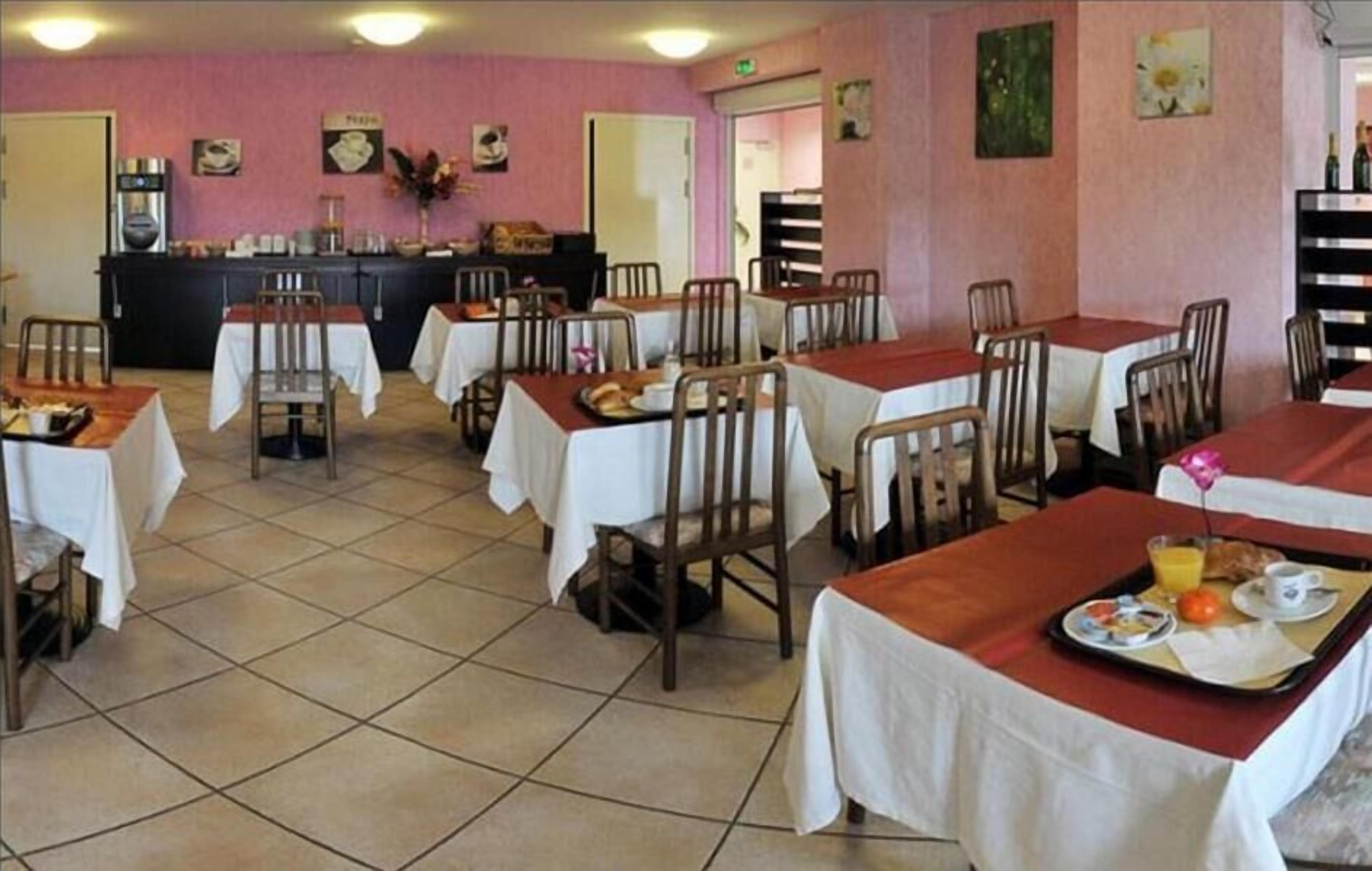A dining area with tables set for breakfast, a coffee machine, and a counter with food items.