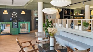 A hotel reception area with a check-in counter, seating area, and decorative shelves. - B&B Hotel Barcelona Granollers (Les Franqueses del Valles)
