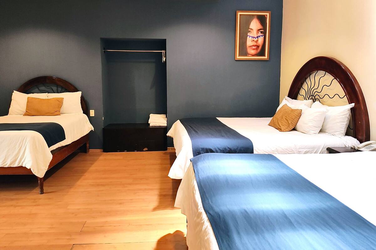 Ein Hotelzimmer mit zwei Betten, einem Schrank und einer Tür zum Badezimmer.