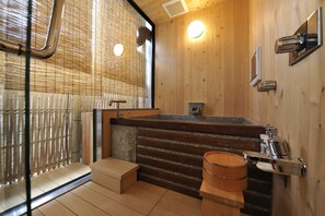 A wooden interior with a stone sink, a wooden bench, and a glass partition. - Ryoan Kazuki (Kyoto)