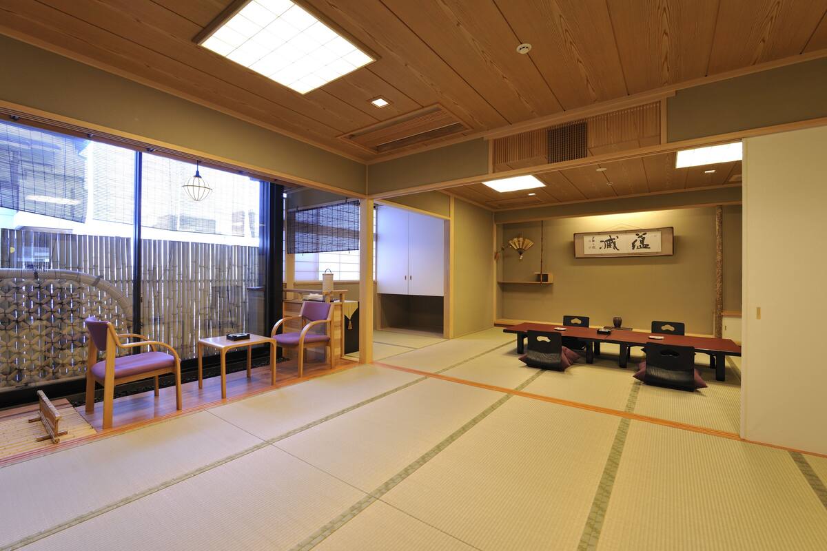 A traditional Japanese room with tatami flooring, wooden furniture, and sliding doors.