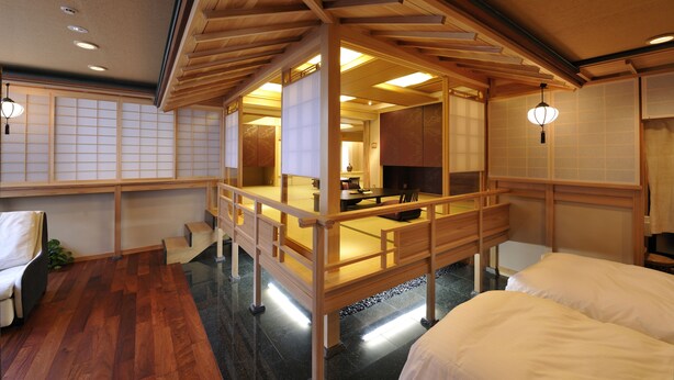 Una habitación de estilo japonés tradicional con suelo de tatami, una mesa de madera baja y un puertas correderas.