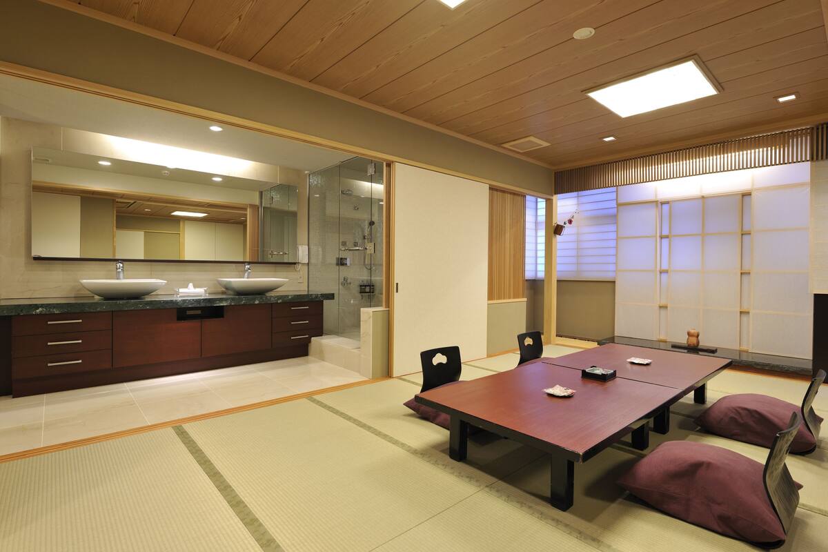 A traditional Japanese-style room with tatami flooring, a wooden table, and a large mirror.