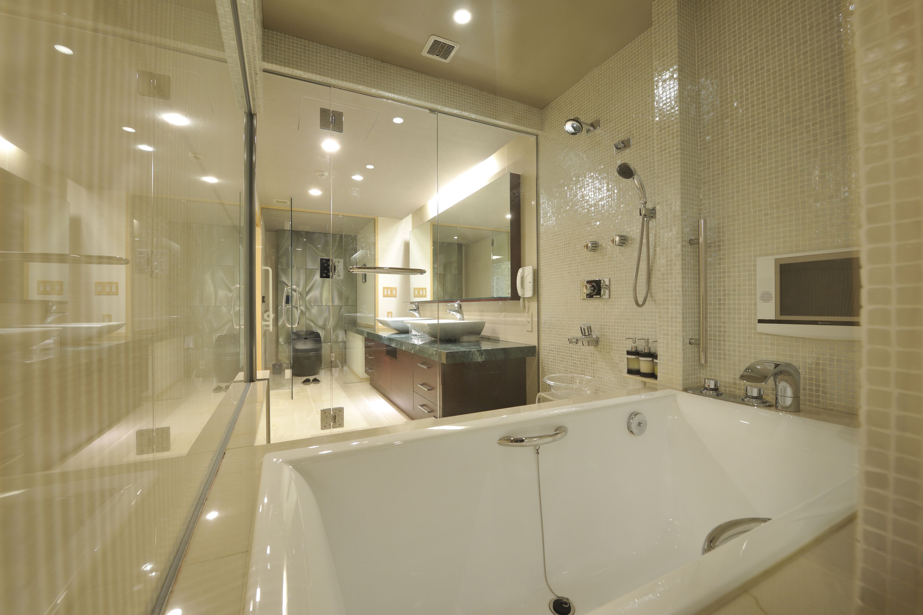 A modern bathroom with a large bathtub, a glass-enclosed shower, and a vanity with a sink.