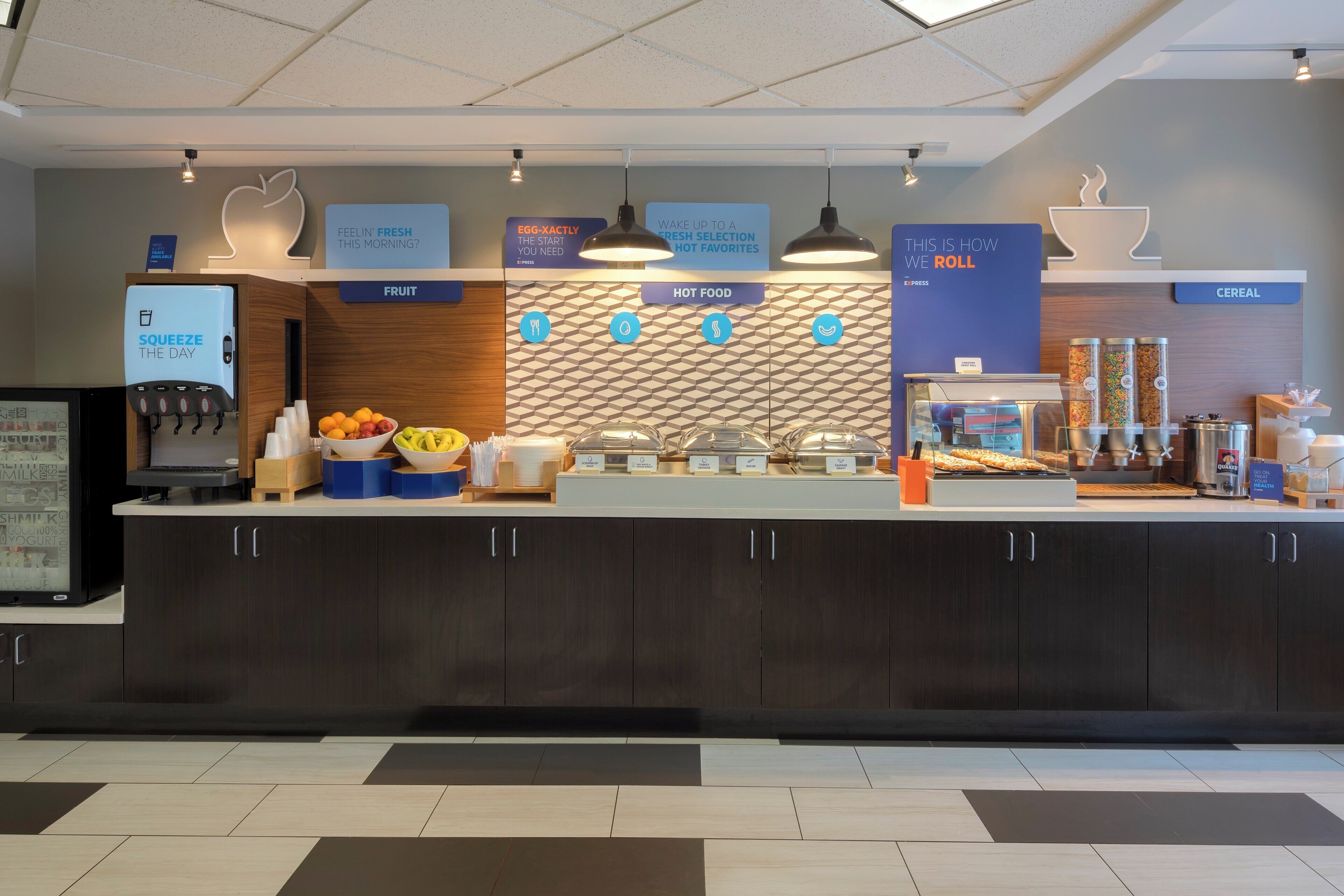 A self-service breakfast area with labeled sections for fruit, hot food, and cereal.