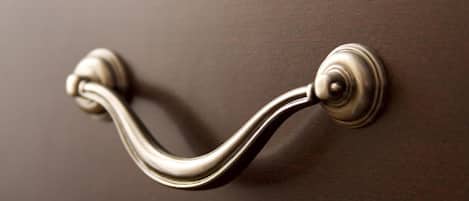 En dørhåndtag med en rund knop og et buet håndtag.