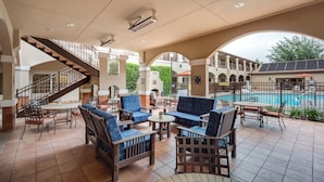 Zona junto a la piscina con mobiliario exterior, una escalera y vistas a la piscina.