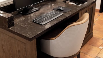A home office setup with a desk, computer, keyboard, mouse, and chair.