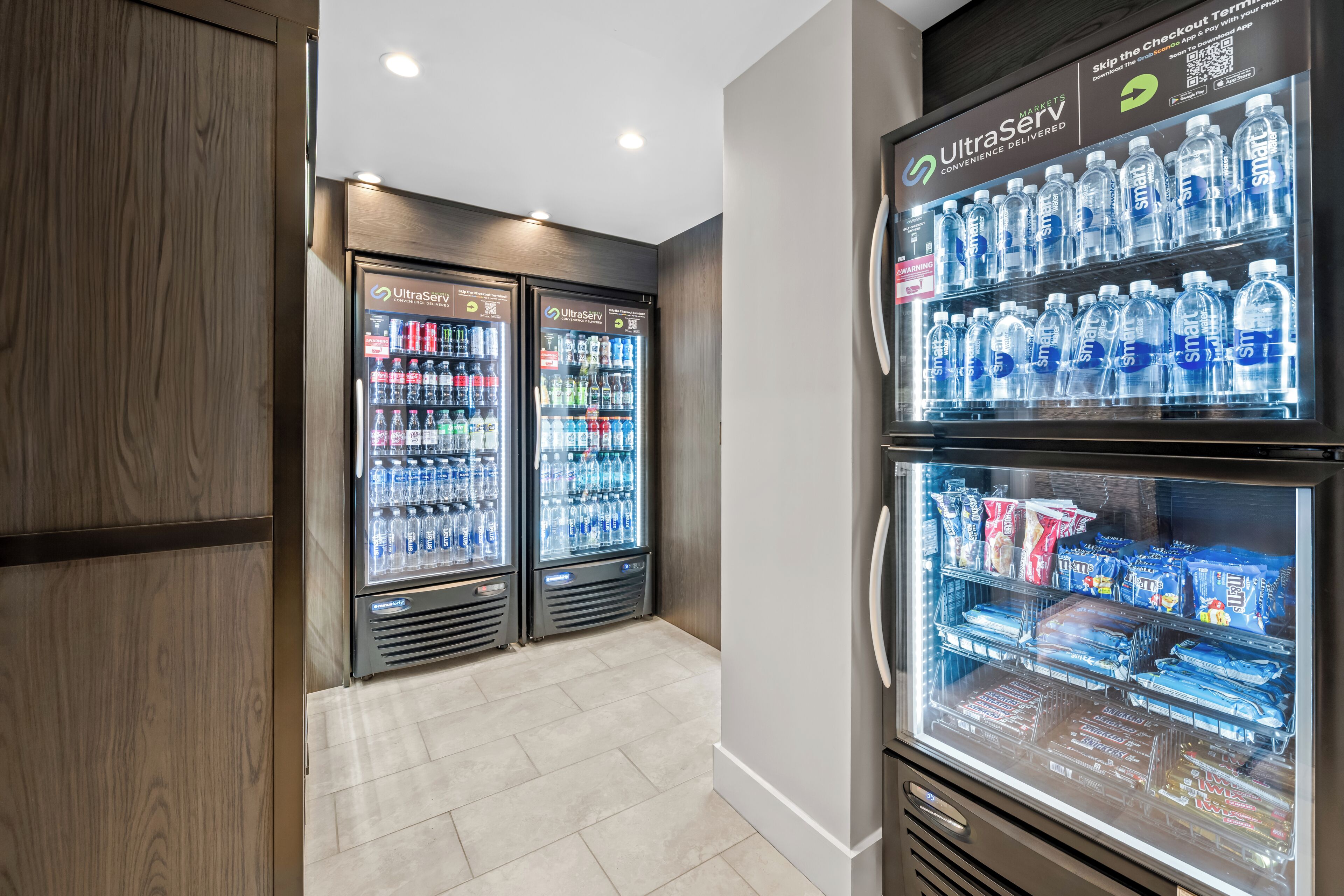 Zona de venta con dos refrigeradores, uno con agua embotellada y el otro con aperitivos.