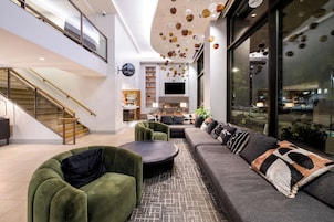 A modern interior with a staircase, seating area, and a dining space.