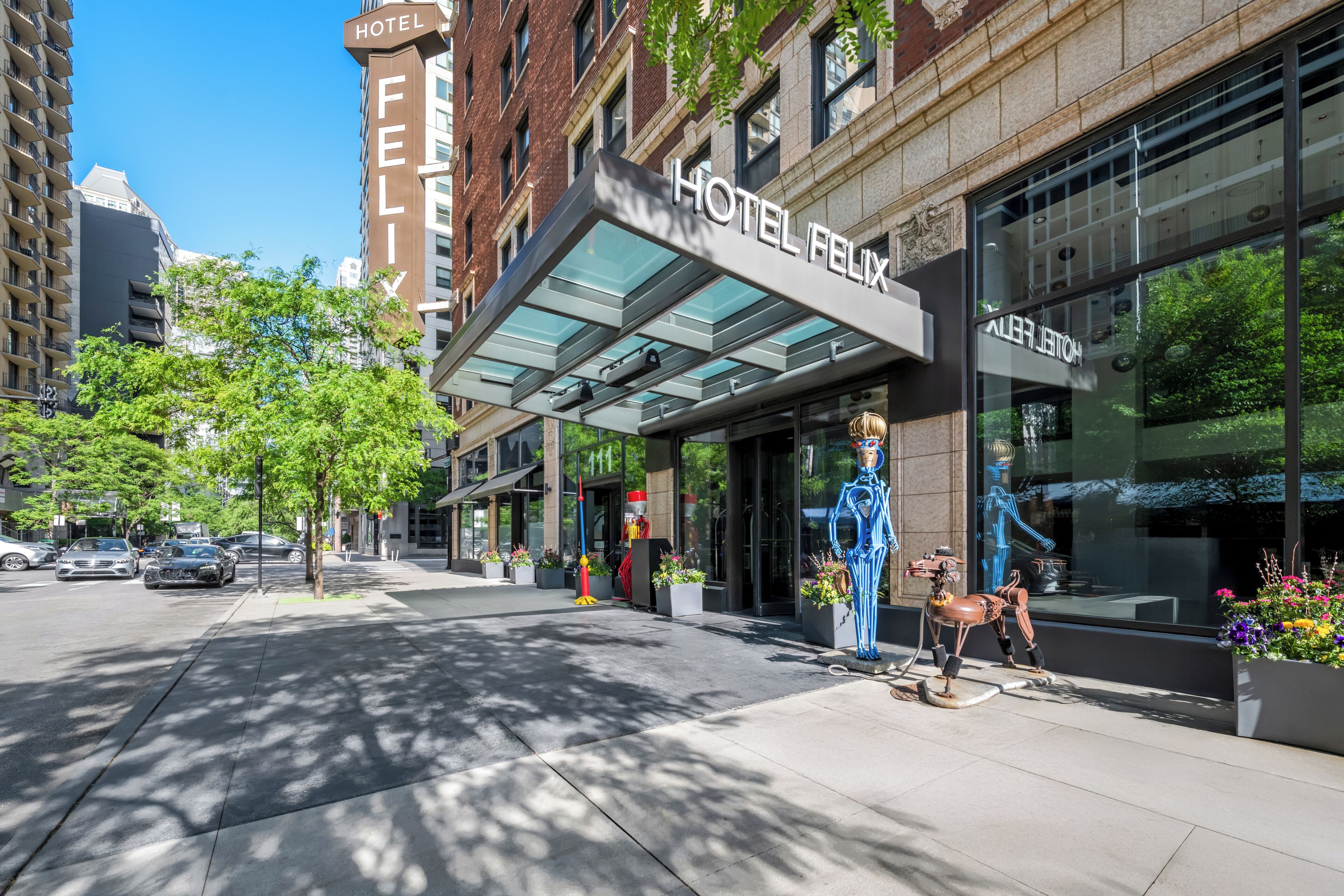 A hotel with a modern facade, large windows, and a clear sky.