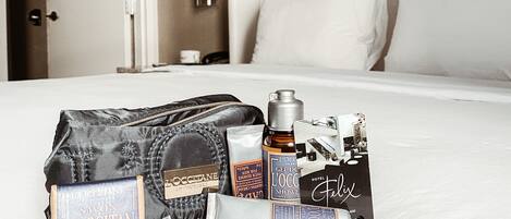 A hotel room with a neatly made bed, a bedside table, and a nightstand.