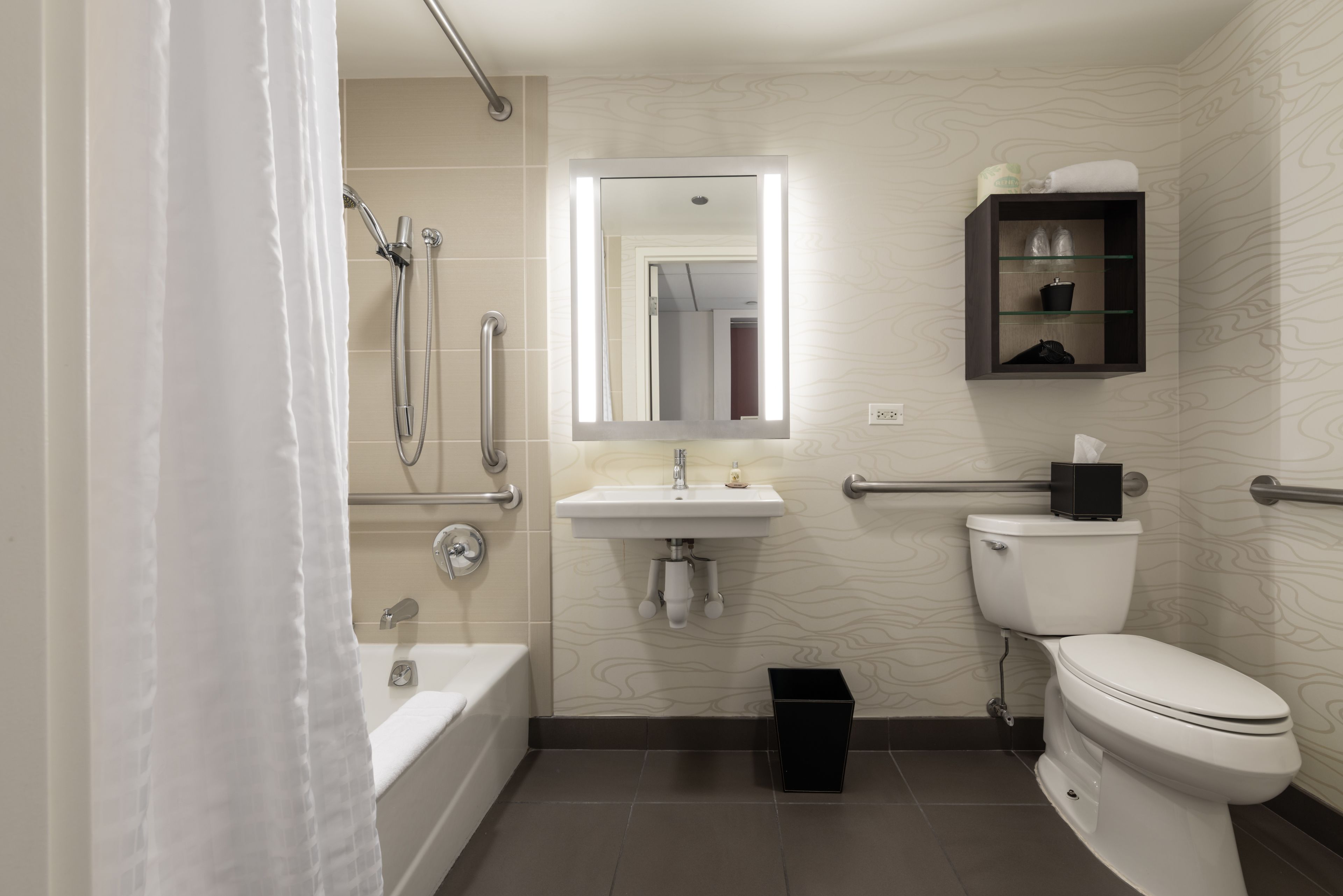 Et moderne badeværelse med badekar, toilet, vask og brusebad.