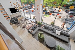 Un interior moderno con una zona de estar, mesas y una chimenea.