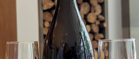 A bottle of Lamarca Prosecco sparkling wine with two empty glasses beside it.