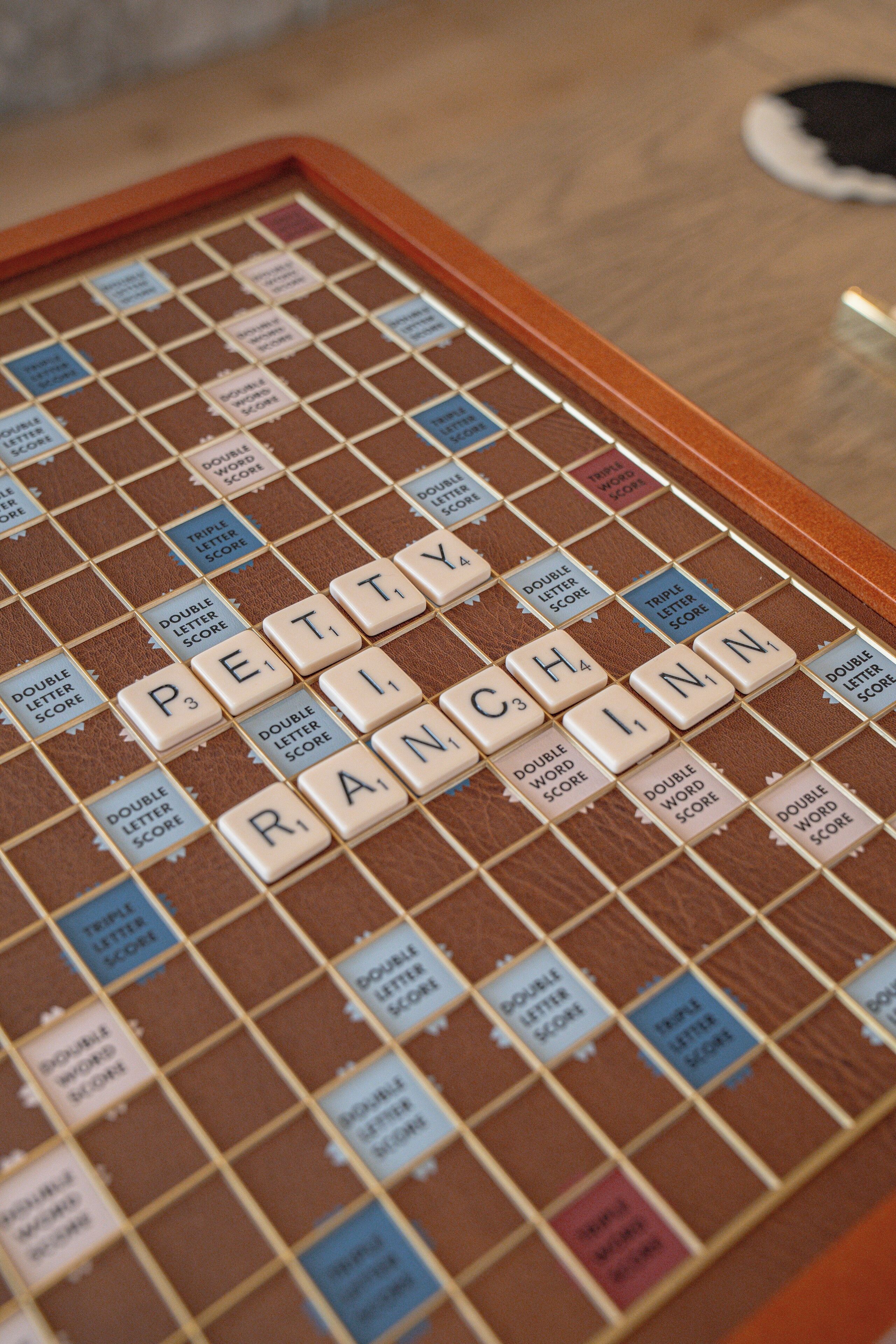 A Scrabble board with the word "PETTY" on it.