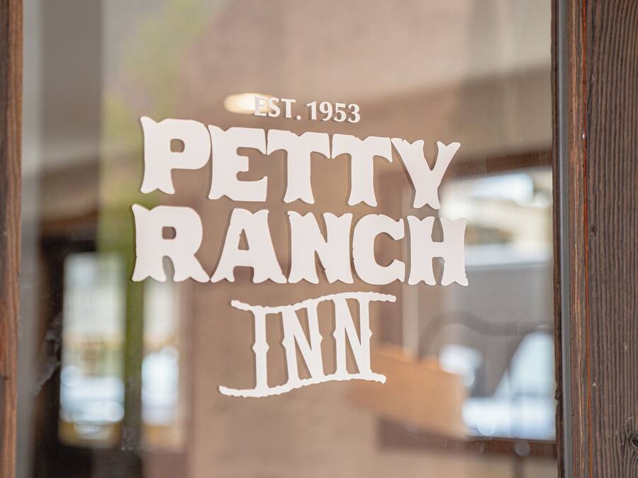 Een raam met de tekst 'PETTY RANCH INN OPGESTART 1953'.