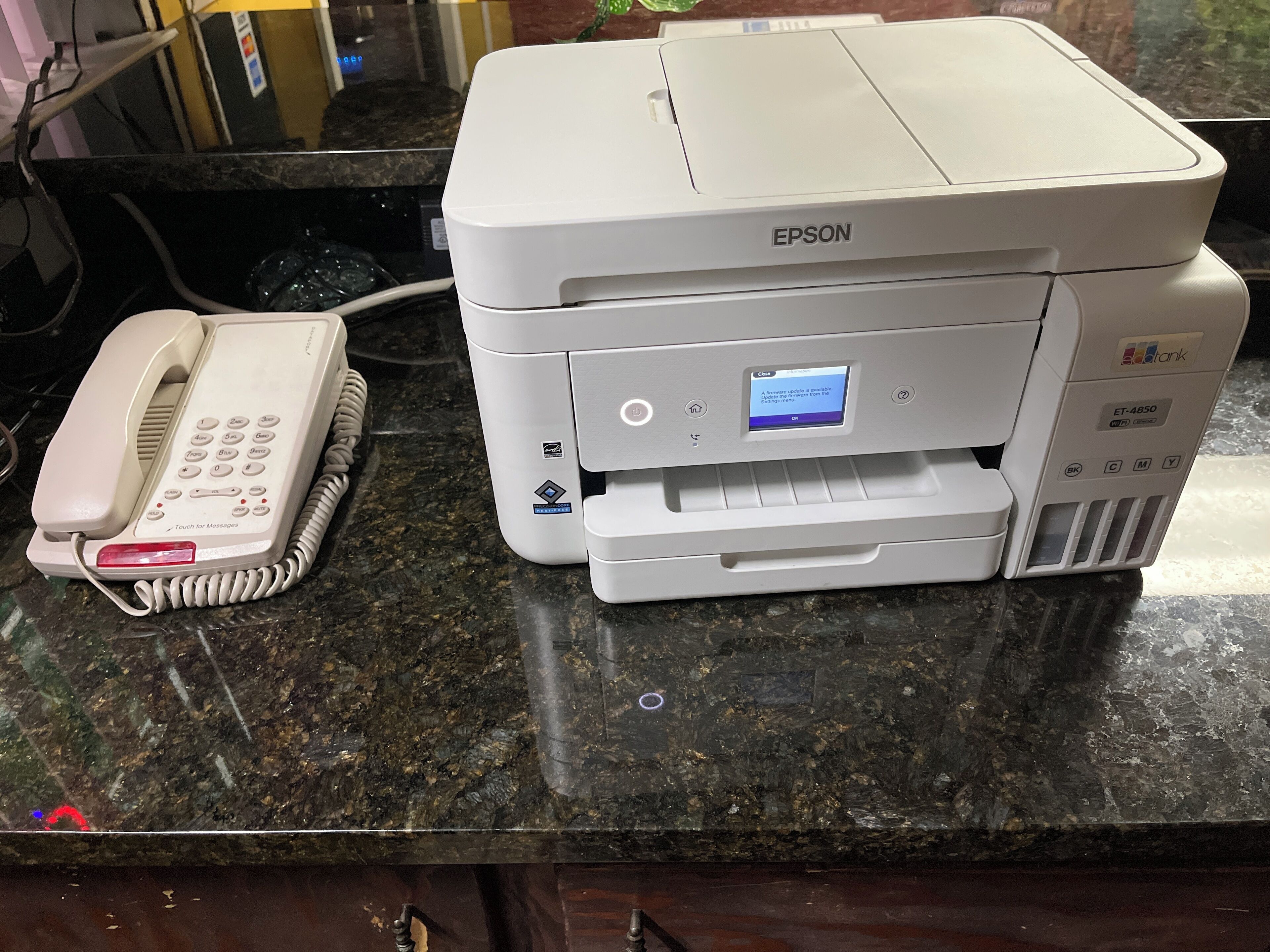 A printer with a display screen on a countertop.