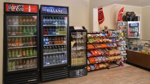 Ein Kiosk mit Getränkeautomaten, Snackregalen und einer Kasse.