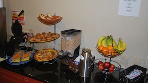 Ein Frühstücksbuffet mit verschiedenen Speisen und einem Schild, das den Frühstücksbereich kennzeichnet.