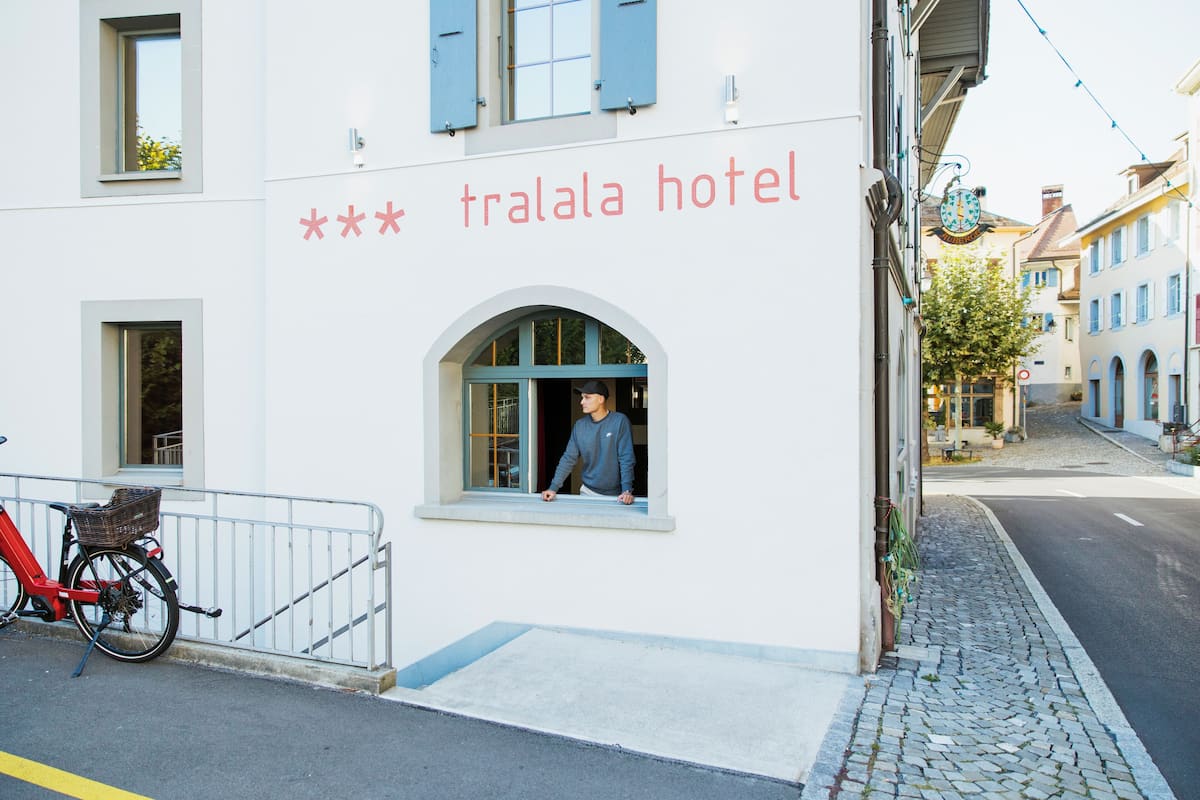 A building with a sign reading "tralala hotel" and a bicycle parked outside.