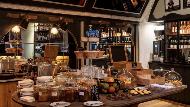 A breakfast buffet with various food items and a bar area with bottles.
