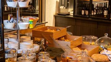 Buffet com diversos alimentos, máquina de café e exibição de vinhos.