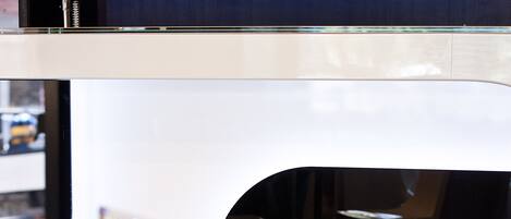 Een modern interieur met een witte stoel en een gebogen wit aanrecht.