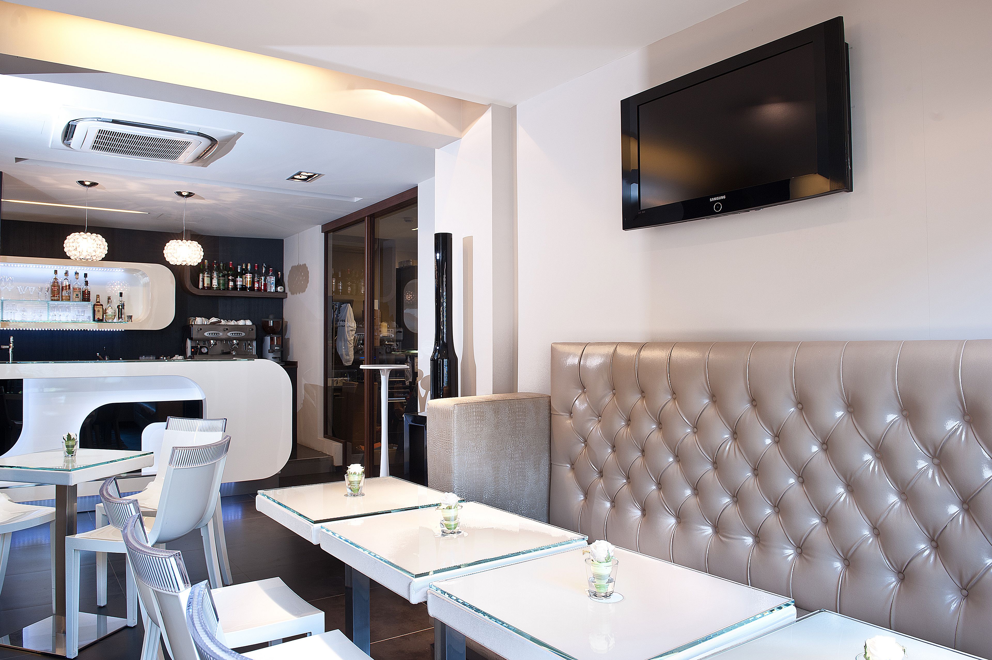 Eine moderne Bar mit Theke, Sitzgelegenheiten und einem an der Wand befestigten Fernseher.