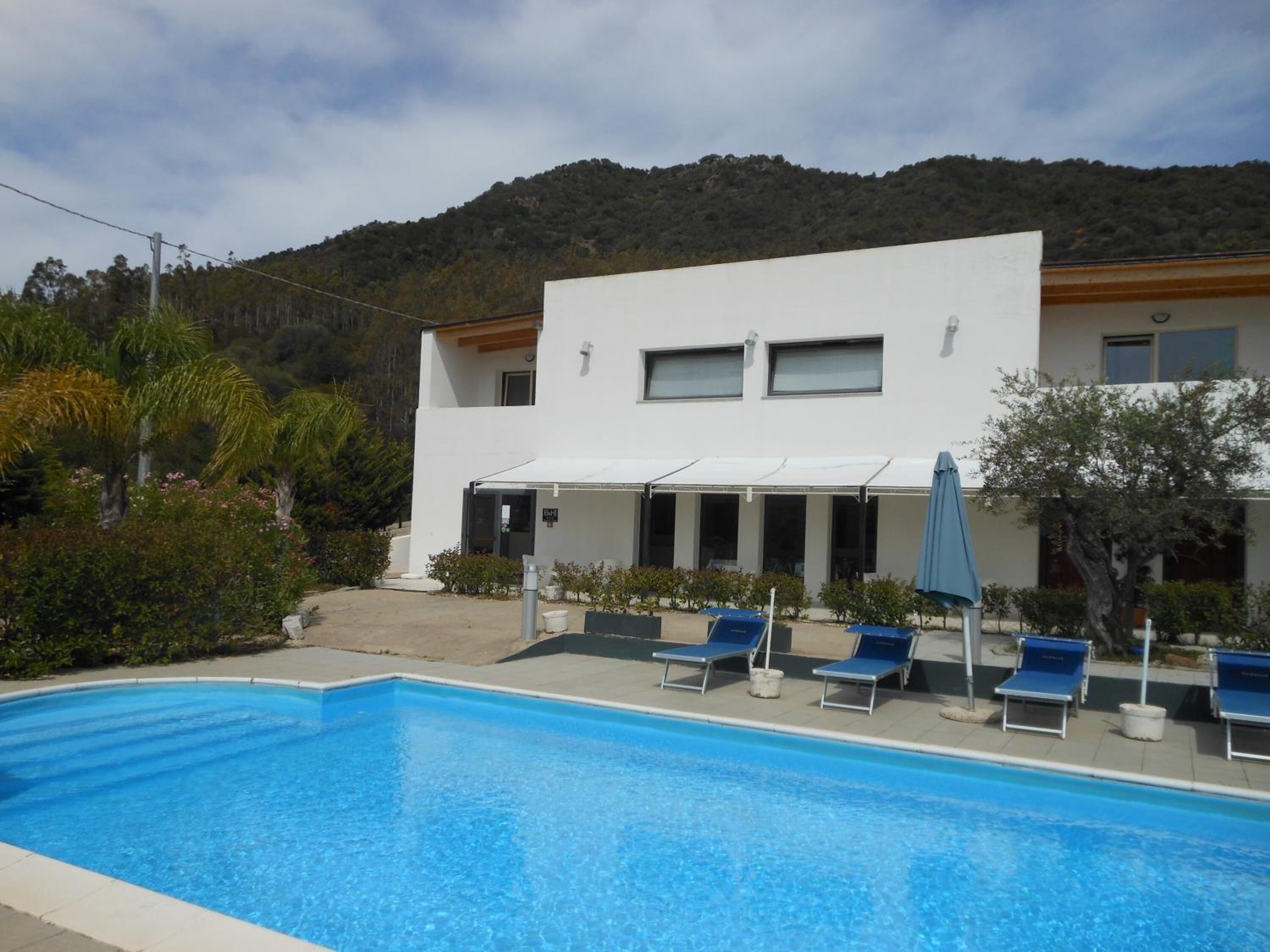 Ein modernes Gebäude mit Pool und Liegestühlen.