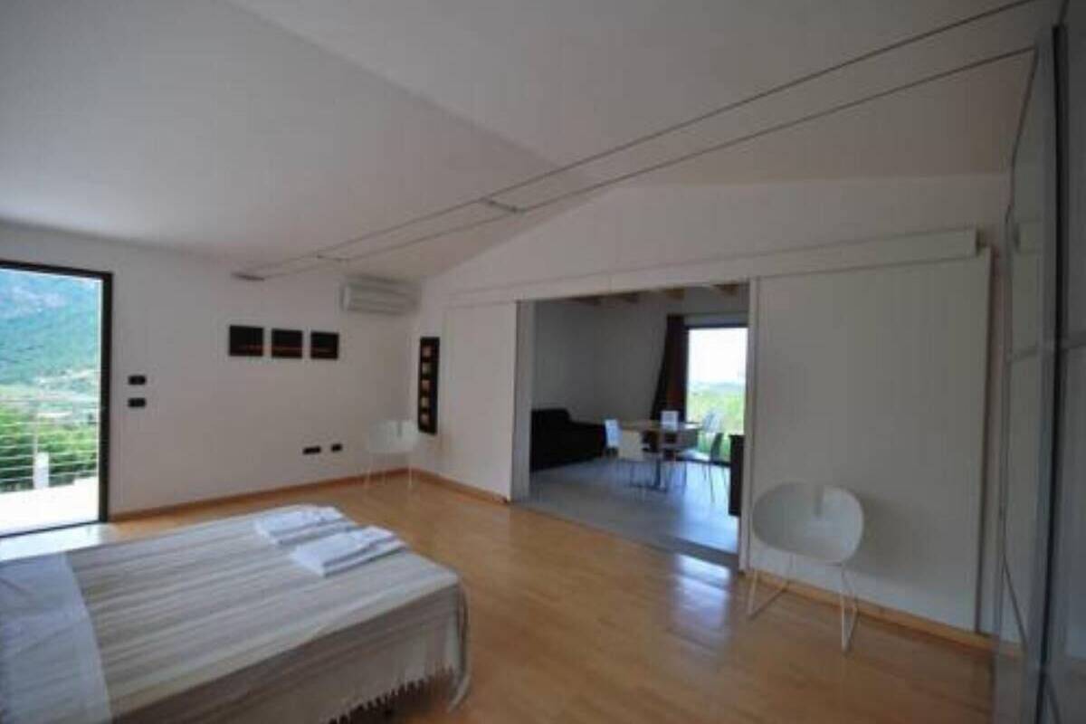 A modern bedroom with a large window, a bed, and a view of a balcony.