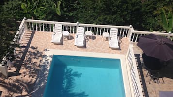 Una piscina al aire libre, tumbonas