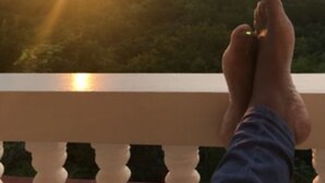 A hand holding a key with the text "WELCOME TO RETREAT GUESTHOUSE" over a scenic sunset view.