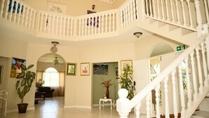 A spacious interior with a grand staircase, multiple levels, and a well-lit atrium.